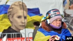 Участница антиправительственных демонстраций в Киеве на фоне портрета Юлии Тимошенко, 30 января 2014 года. 