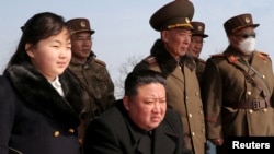 Севернокорејскиот лидер Ким Џонг ун и неговата ќерка Ким Џу Ае гледаат ракетна вежба на непозната локација. Сликата е објавена од Централната новинска агенција на Северна Кореја (КЦНА) на 20 март 2023 година.