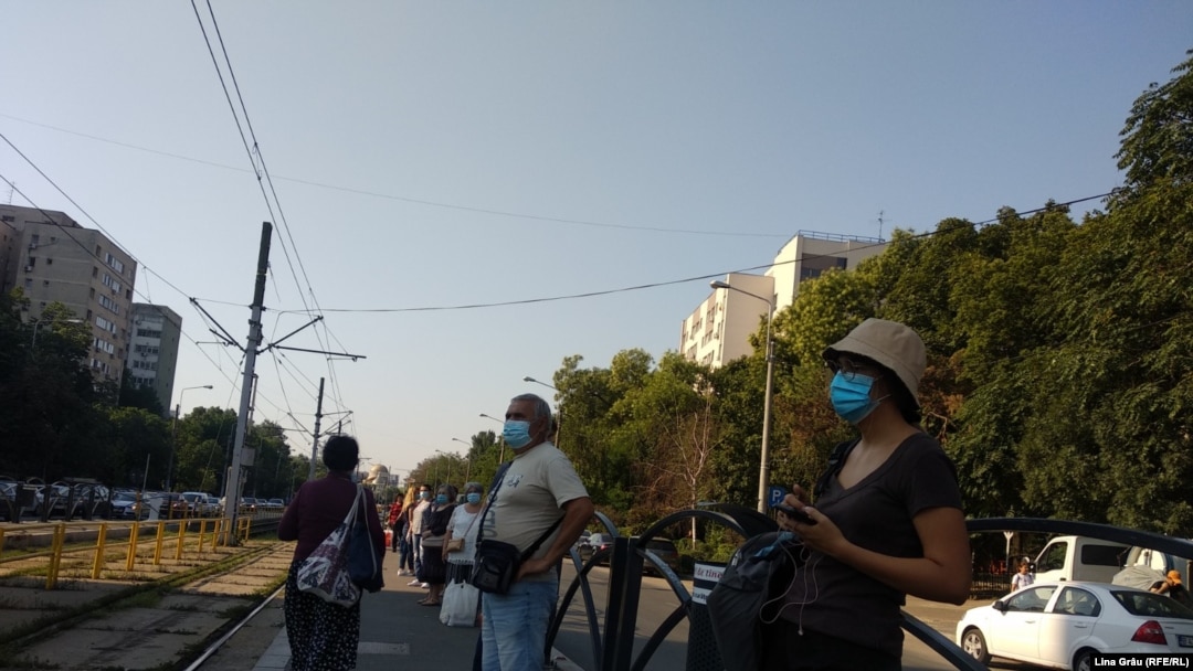 România -- București, stație de așteptare a transportului public, pasageri cu mască, 16Jul 2020