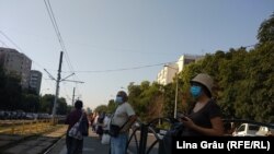 România -- București, stație de așteptare a transportului public, pasageri cu mască, 16Jul 2020