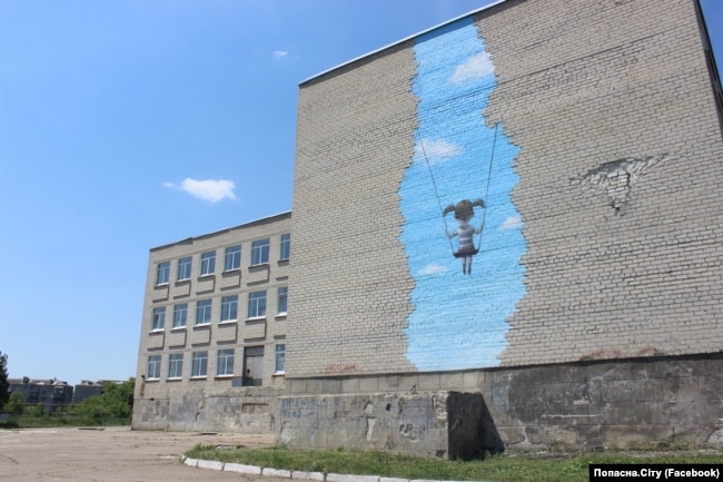 Мурал французького художника Жульєна Маллана на школі №1 у Попасній. На відновленій будівлі символічно залишили слід віл влучання «Граду»