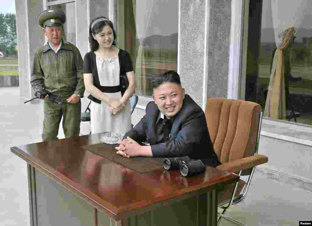 North Korean leader Kim Jong Un (front) and his wife, Ri Sol Ju, look on during a visit to Unit 1017 of the Korean People&#39;s Army. (Reuters/KCNA)
