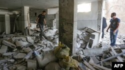 Disa persona duke i kontrolluar dëmet brenda një ndërtese në Bregun e uzurpuar Perëndimor në qytetin Jenin, pas një sulmi ajror izraelit më 22 tetor 2023.