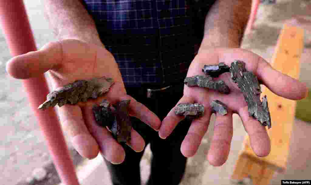 A man shows artillery shell fragments in the Azerbaijani village of Agdam.