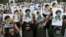 Shia Muslims holding portraits of Iran’s slain supreme leader Ali Khamenei and of his son, the country's new supreme leader Mojtaba Khamenei, shout anti-US-Israel slogans during the Youm-e-Ali procession in Karachi on March 11, 2026 marking the death anni