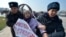 Kyrgyz police arrest a woman protesting against gender-based violence to mark International Women's Day in Bishkek in March 2020.