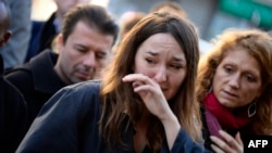 Mourners on November 15 look on at a memorial site outside of the Le Belle Equipe restaurant, in the 11th district of Paris, for victims of the November 13 terrorist attacks in Paris.