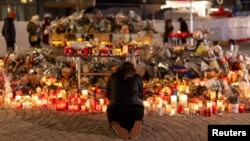 Qirinj dhe lule në nderim të viktimave të zjarrit në Zvicër. 