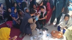 مردی در دایکندی دخترانی که گفته می‌شود مسموم شده‌اند را مدوا می‌کند