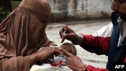 A Pakistani health worker administers polio drops to a child during a polio vaccination campaign in Peshawar on March 3.