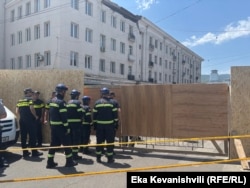 სამაშველო სამსახურის თანამშრომლები შედიან შემოღობილ ტერიტორიაზე.