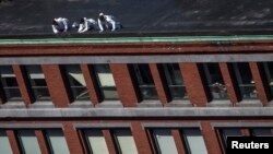 Hetuesit amerikanë në kulmin e ndërtesës prej nga shihet vendi ku ndodhën dy eksplodimet në maratonën e Bostonit ditën e hënë