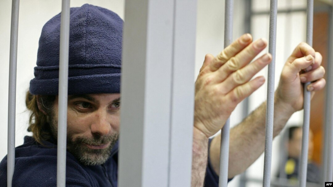 British Greenpeace International activist Iain Rogers holds the bars of a cell during his bail hearing in Russia on October 22. 