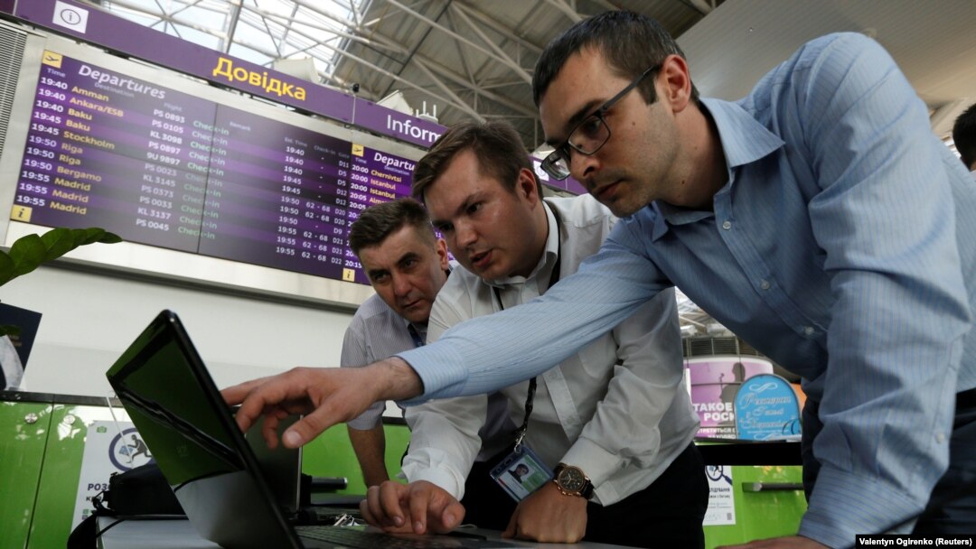 Technicians work on a flight timetable for the website of Ukraine's Boryspil Airport near Kyiv following a cyberattack on June 27 that started in Ukraine before spreading elsewhere. 