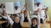 Belarus -- Pupils hold books about President Alyaksandr Lukashenka at a school in Minsk, September 1, 2012