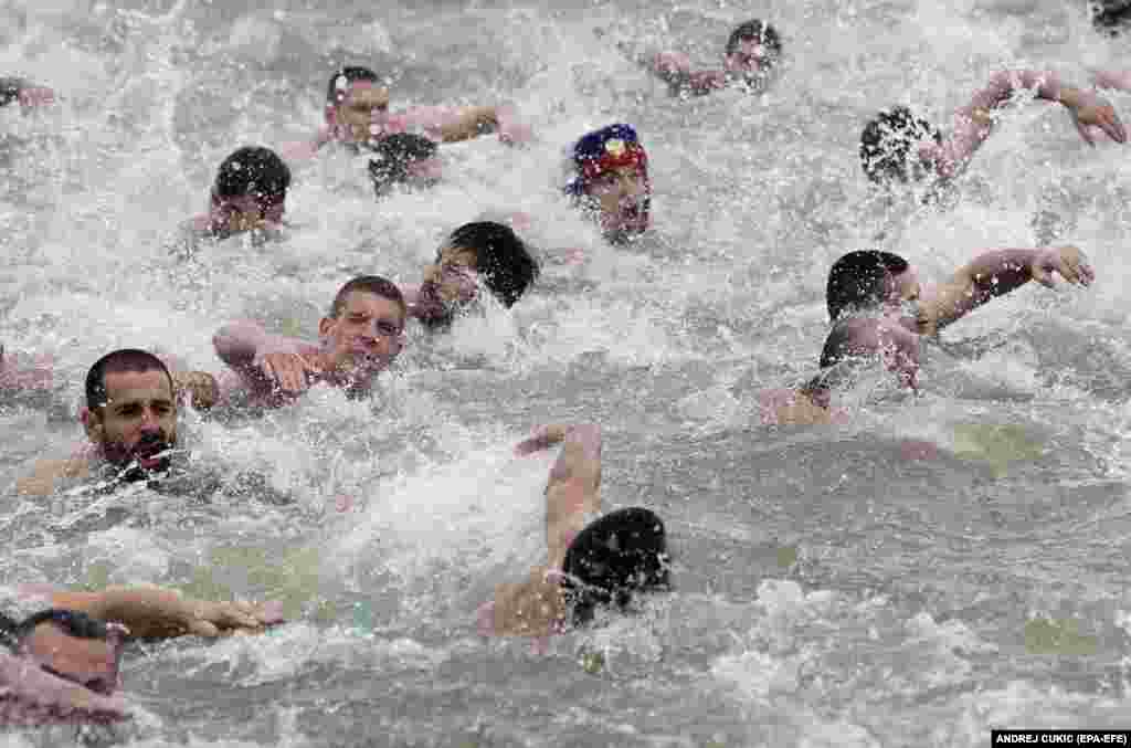 Serbian Orthodox believers swim in the cold water of the Danube River during celebrations of the Epiphany in Belgrade. People believe that swimming in blessed waters during the holiday of Epiphany strengthens their spirit and body. (epaA-EFE/Andrej Cukic)