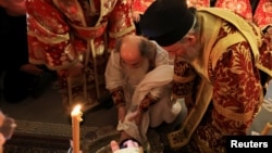 Patriarhul grec Teofil al III-lea spală picioarele unui credincios la Ierusalim, pe 9 aprilie. Locurile sfinte din Israel s-au redeschis după 40 de zile, săptămâna aceasta, chiar înaintea Paștelui ortodox.