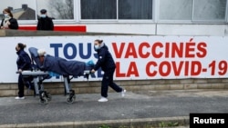 Ženu nose na nosilima u centar za vakcinaciju protiv COVID-19 tokom posjete francuskog ministra zdravlja Oliviera Verana bolničkoj grupi South Ile-de-France, u Melunu, na periferiji Pariza, 8. februara 2021. 