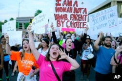 Protest în Phoenix, Arizona, împotriva anulării deciziei Roe v Wade, 24 iunie 2022. Pe pancartele demonstranților: „Trupul meu, alegerea mea”, „Sunt o femeie, nu un pântec. Un părinte dacă aleg să fiu”, „Pro-viață e o minciună. Nu vă pasă dacă femeile mor”.