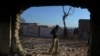 A Pakistani policeman stands guard at a badly damaged Hindu shrine after it was attacked by a mob in the Karak district, some 160 kilometers southeast of Peshawar. 