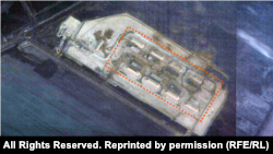 Паўночны ўчастак будаўніцтва вайсковага аб’екту на спадарожнікавым здымку 18 сьнежня 2025 году. Абведзеныя 8 каркасаў будынкаў, падобных на ангары разам з абарончымі землянымі валамі.