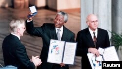 Norway -- African National Congress (ANC) leader Nelson Mandela (C) holds up the medal and certificate after he was jointly awarded the 1993 Nobel Peace Prize with South African President F.W. de Klerk (R) at a ceremony at Oslo's city hall, 10Dec1993