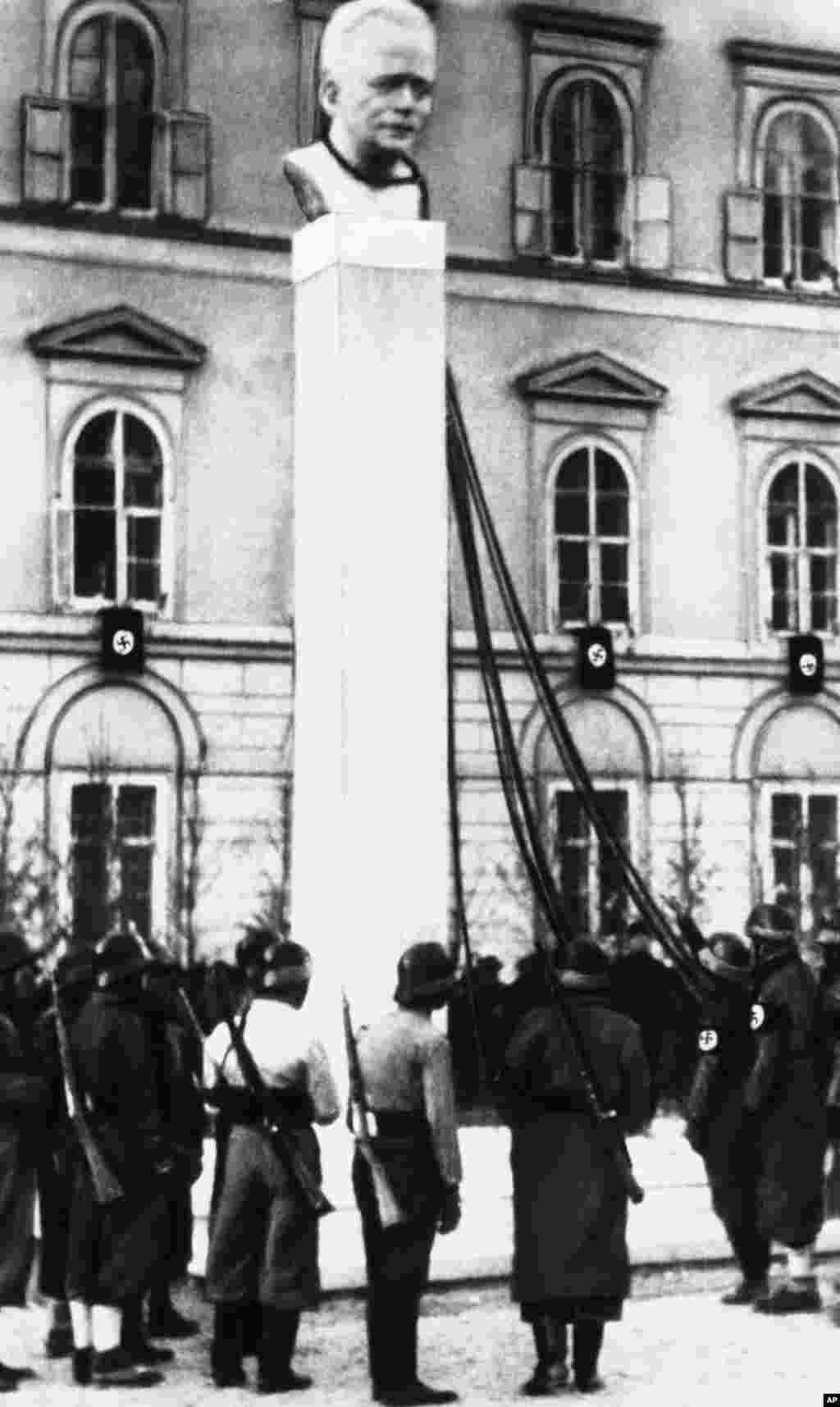 Нацистки войници в очакване на заповед за сваляне на бюста на австрийския канцлер Енгелберт Долфус. Това се случва след анексията на Австрия от нацистка Германия през 1938 г.