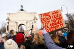 Demonstrant drži plakat sa natpisom "Oni koji ne uče iz istorije osuđeni su da je ponavljaju" tokom demonstracija protiv AfD u Minhenu. 21. 1. 2024.