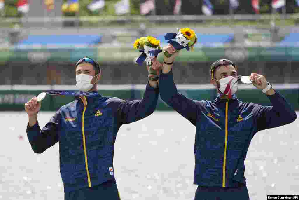 Marius Cozmiuc and Ciprian Tudosa of Romania pose with the silver medal in the men&#39;s rowing pair final at the 2020 Summer Olympics, Thursday, July 29, 2021, in Tokyo, Japan.