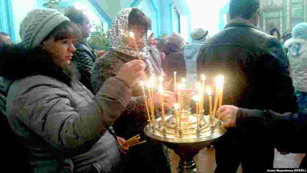 Зыяратка келгендер өткөндөрдү эскерип шам коюшат.