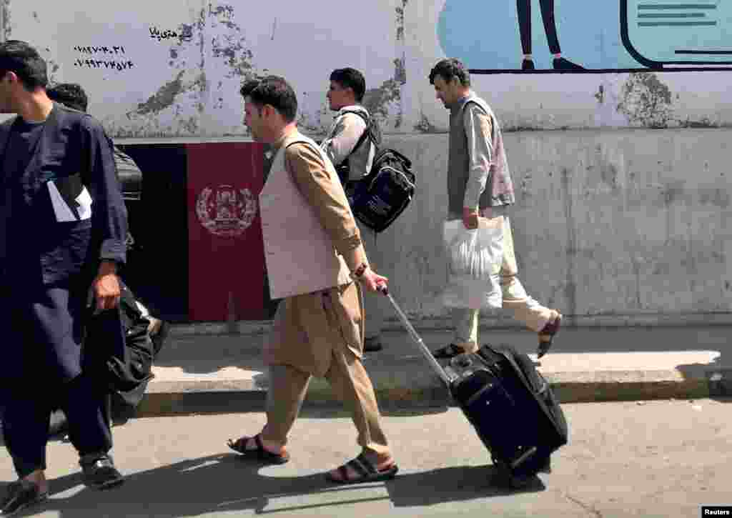 Afghans walk toward the airport in Kabul. There are reports of huge traffic jams on the road to the airport, as people look to leave before the Taliban takes the city.