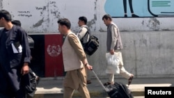 Афганські пасажири йдуть до аеропорту в Кабулі, 15 серпня 2021 року