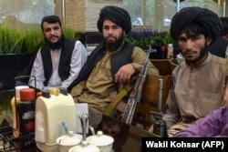Tálib harcosok várják, hogy felszolgálják az ebédjüket egy kabuli étteremben
