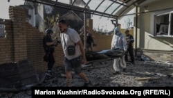 A dead body is carried out of a house in the Ukrainian village of Myla, near Kyiv, following a detonation at a local warehouse after a Russian strike on August 29.