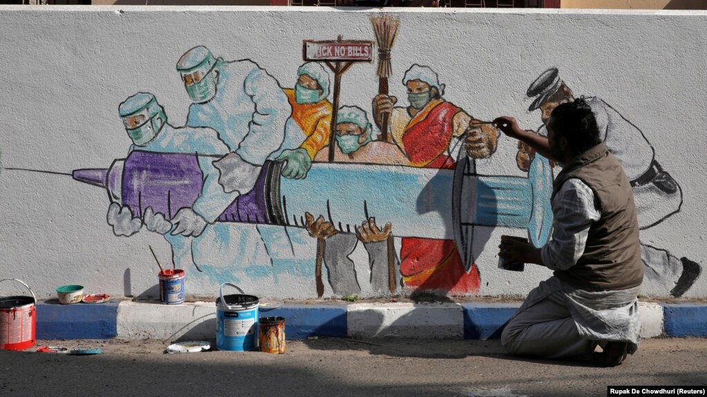 Художник в Калькутте наносит граффити, посвященное началу вакцинации от коронавируса