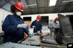 Radnici demontiraju laptope u centru za reciklažu u Najrobiju, Kenija, mart 2024.