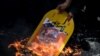 A nukleáris egyezményből kilépő Donald Trump fotóját égetik egy teheráni tüntetésen 2018-ban.