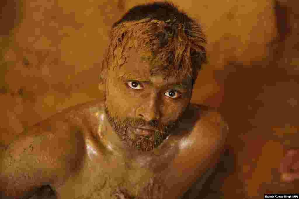 An Indian wrestler looks on after a bout during the Nag Panchami Festival in Prayagraj, India. Every year, the wrestlers offer prayers and hold bouts to mark the festival, which is primarily dedicated to the worship of snakes. (AP/Rajesh Kumar Singh)