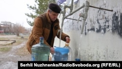 A Ukrainian man stocks up on fresh water supplies in Pokrovsk as Russian troops gain ground in their march toward the strategic city.