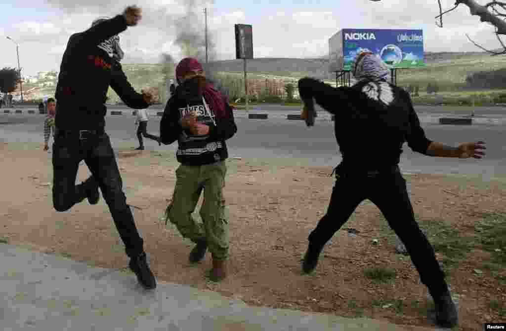 Palestinian protesters throw stones toward Israeli forces during clashes at Hawara checkpoint near the West Bank city of Nablus on March 1. (Reuters/Abed Omar Qusini)