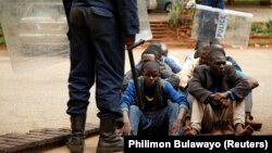 Арыштаваныя зымбабвійцы чакаюць сваёй чаргі для зьяўленьня перад судом. Харарэ, 16 студзеня 2019