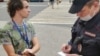 Полицейский переписывает данные сборщика подписей в поддержку кандидата в депутаты Рины Мацапулиной