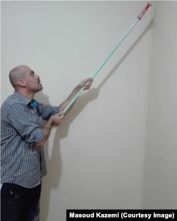 Gazetari Masoud Kazemi duke ngjyrosur një banesë.