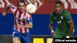 Игрок Atletiko Madrid с надписью «Азербайджан» на футболке Диего Годин (слева) борется за мяч с игроком команды «Рубин» (Казань), Мадрид. 14 февраля 2013. Архивное фото.