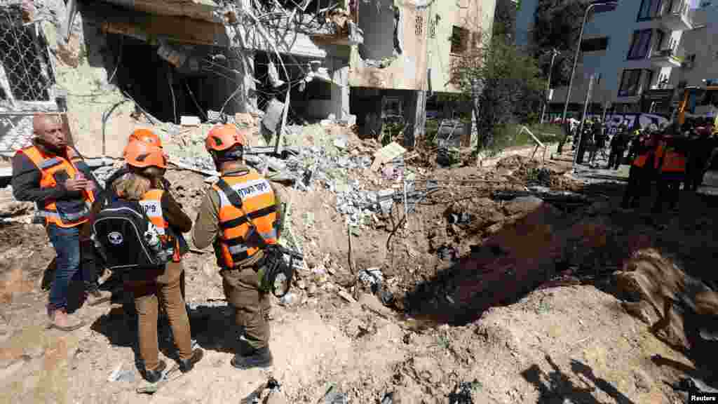 Radnici hitnih službi u Tel Avivu procjenjuju štetu nastalu nakon talasa iranskih raketnih udara u centralnom Izraelu 24. marta.