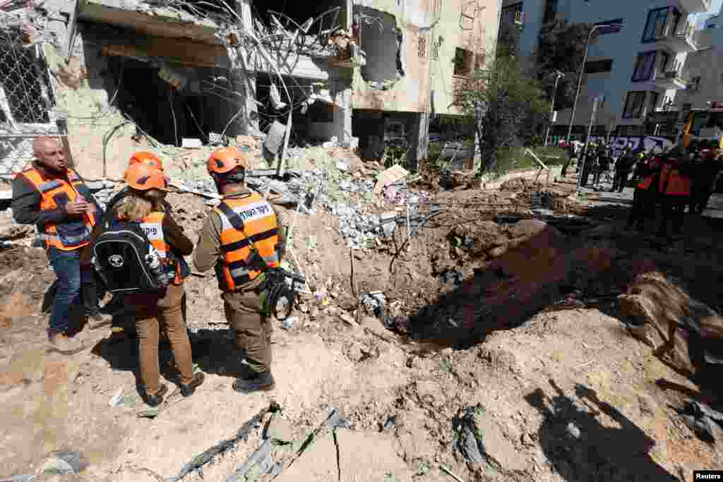 Emergency workers in Tel Aviv assess damage caused by a wave of Iranian missile strikes in central Israel on March 24.