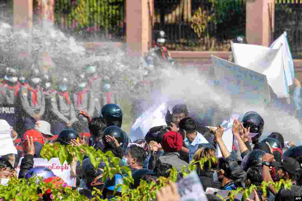 Burmanska policija (u pozadini) puca iz vodenih topova na demonstrante dok nastavljaju demonstracije protiv vojnog puča 1. februara u glavnom gradu Naypyidaw, 9. februara 2021. (Foto STR / AFP)