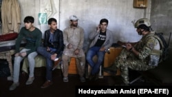 An Afghan soldier speaks with staff from Shamshad TV who were rescued after armed men attacked the TV station in Kabul on November 7. Two security guards were killed in the attack.