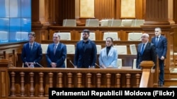 Membri ai echipei guvernamentale, în frunte cu premierul Alexandru Munteanu (al doilea din dreapta), la ședința Parlamentului din 24 martie 2026, când au cerut votul deputaților pentru instituirea stării de urgență în energetică