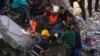 Egy mentőcsapat tagjai egy épület romjai között talált áldozat holttestét emelik ki a törökországi Adanában 2023. február 7-én
